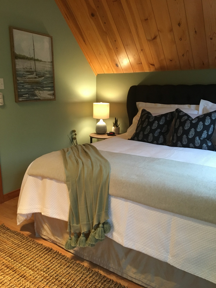 他の地域にある小さなビーチスタイルのおしゃれな客用寝室 (緑の壁、ラミネートの床、オレンジの床)