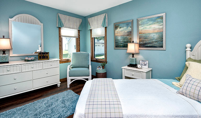 Modelo de dormitorio marinero de tamaño medio sin chimenea con paredes azules y suelo de madera oscura