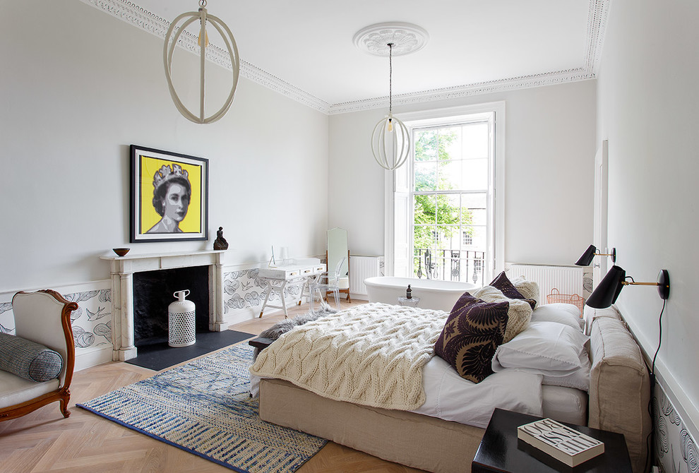Cette photo montre une chambre tendance avec un mur gris, parquet clair, une cheminée standard et un sol beige.
