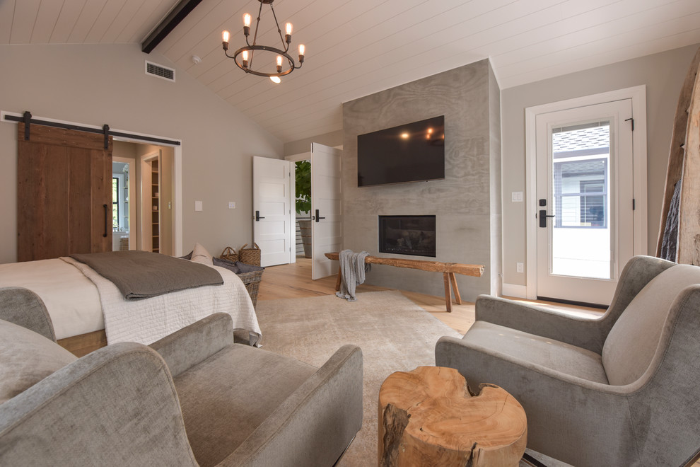 Kleines Modernes Hauptschlafzimmer mit grauer Wandfarbe, hellem Holzboden, braunem Boden, Kamin und verputzter Kaminumrandung in Seattle