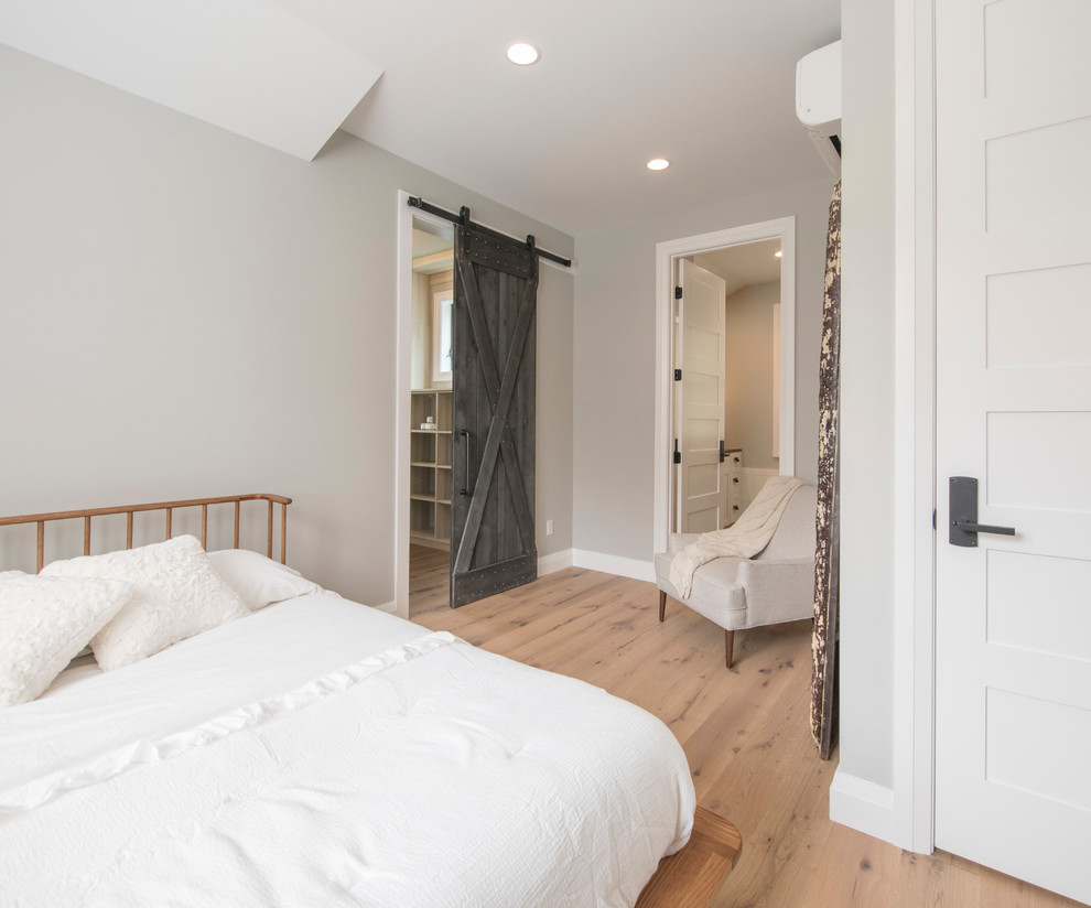 Kleines Modernes Gästezimmer ohne Kamin mit grauer Wandfarbe, hellem Holzboden und braunem Boden in Seattle