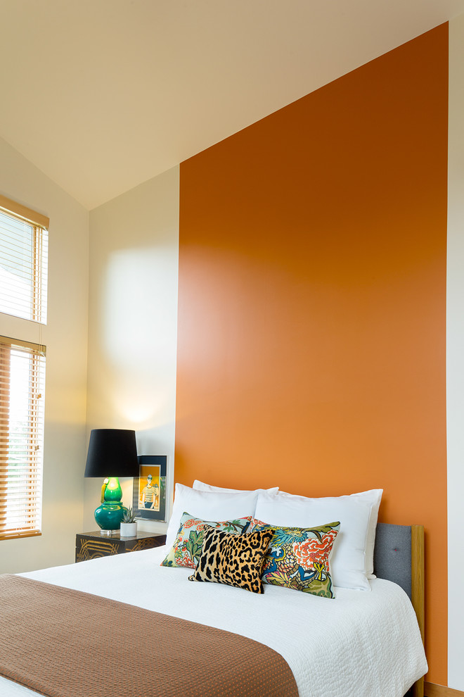 Cette photo montre une grande chambre d'amis asiatique avec un mur orange et un sol en bois brun.