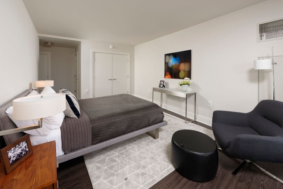 На фото: гостевая спальня среднего размера, (комната для гостей) в современном стиле с серыми стенами и темным паркетным полом без камина