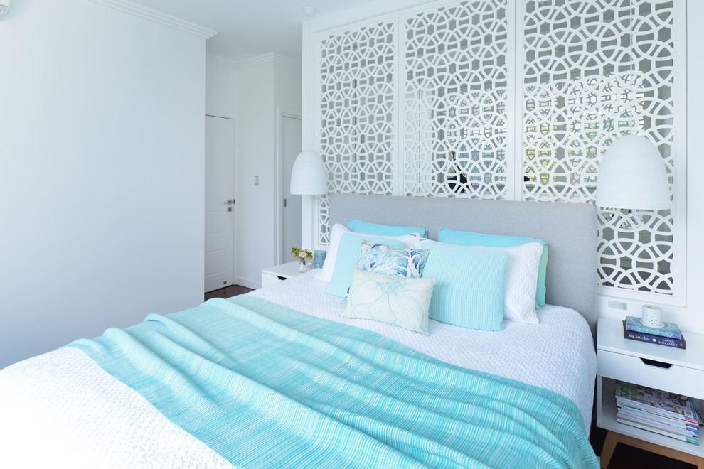 シドニーにある中くらいなビーチスタイルのおしゃれな主寝室 (白い壁、無垢フローリング、暖炉なし、茶色い床)
