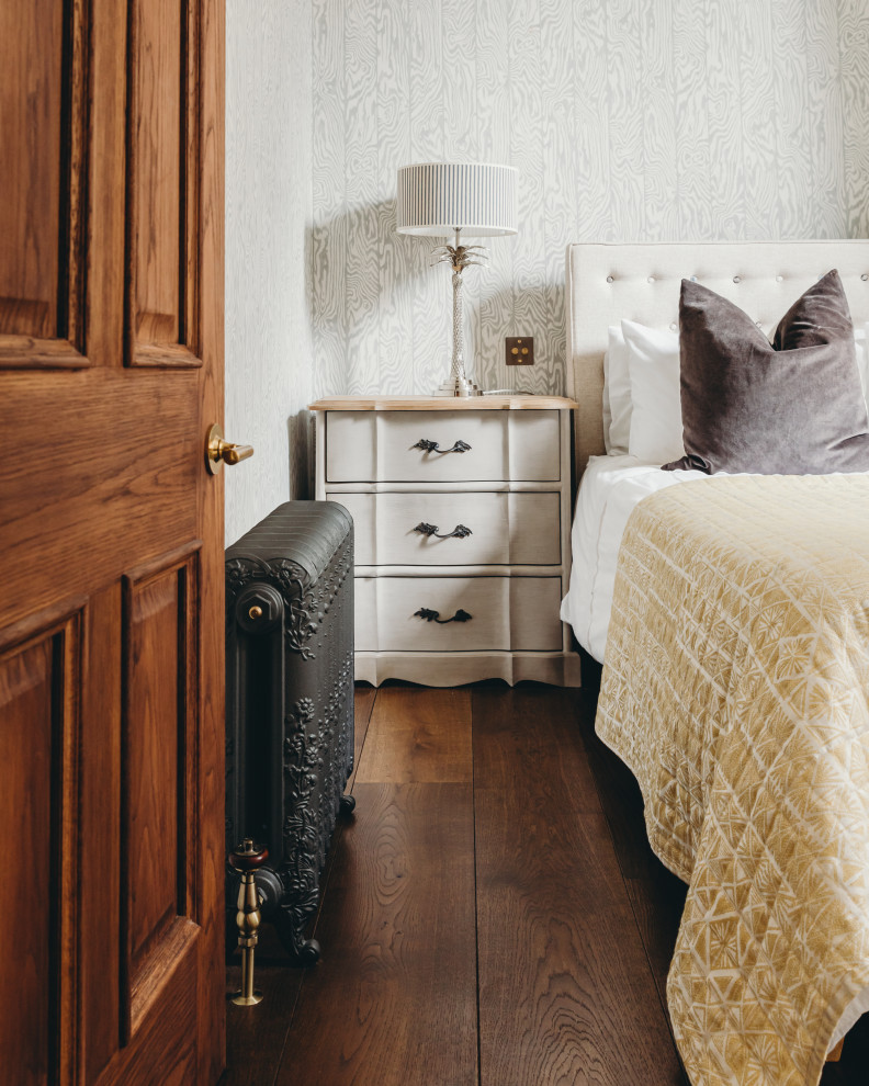 Large trendy guest dark wood floor and brown floor bedroom photo in London with multicolored walls