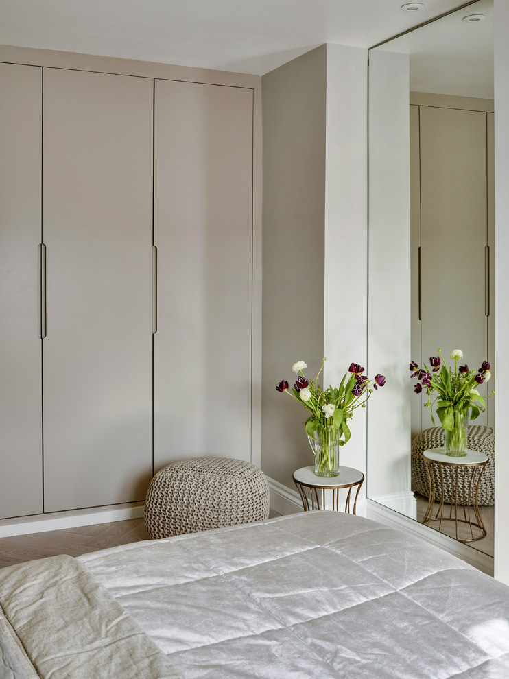 Modelo de habitación de invitados bohemia de tamaño medio con paredes grises y suelo de madera clara