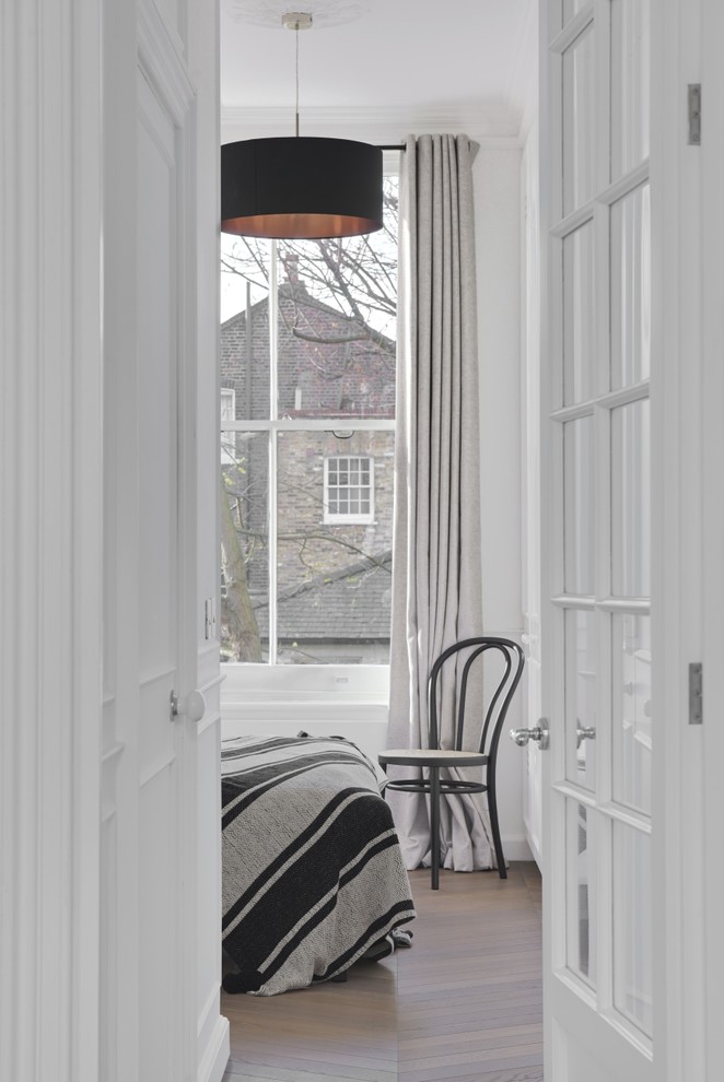 ロンドンにある中くらいなヴィクトリアン調のおしゃれな主寝室 (白い壁、淡色無垢フローリング、茶色い床、暖炉なし)