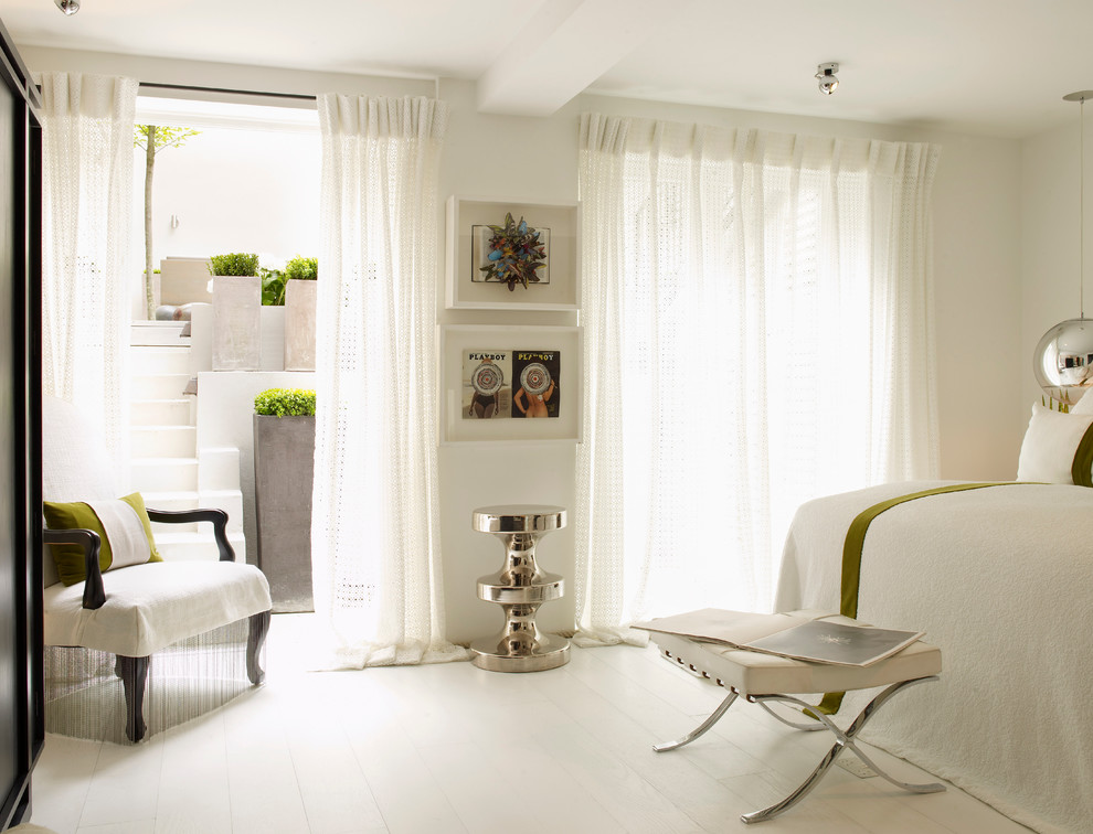 На фото: спальня в современном стиле с белыми стенами, деревянным полом, белым полом и тюлем без камина