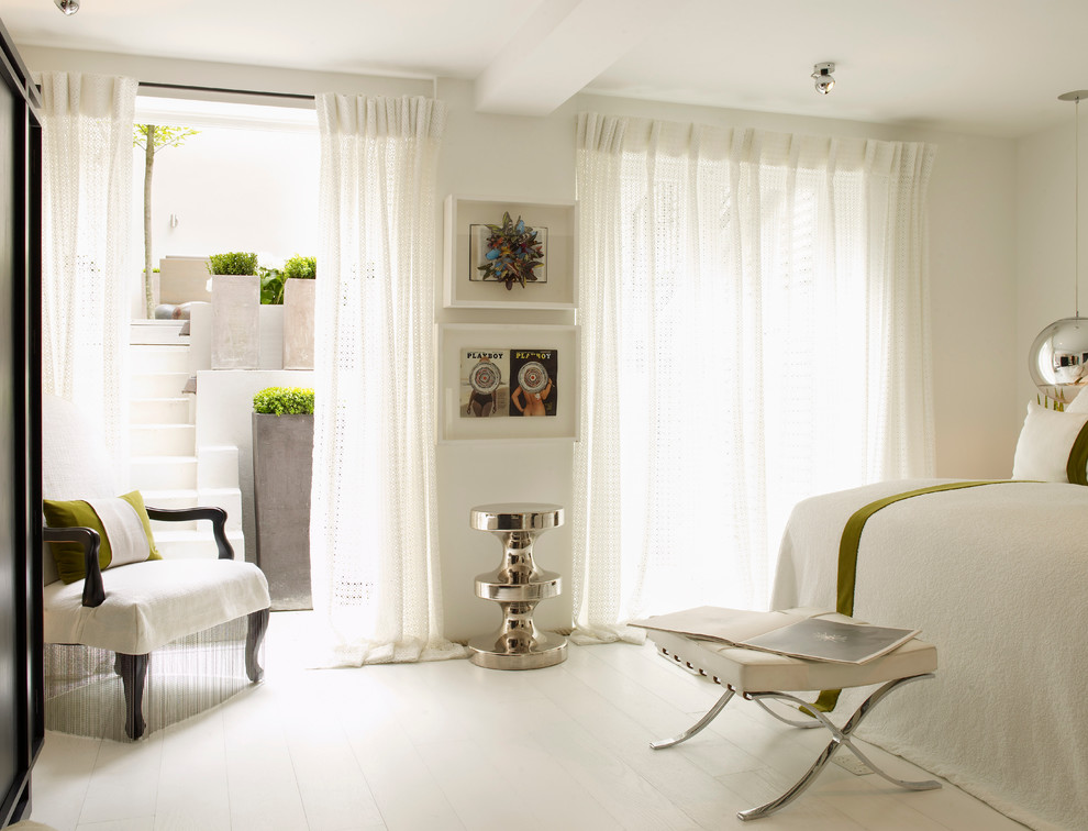 Trendy painted wood floor and white floor bedroom photo in London with white walls and no fireplace