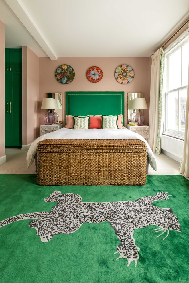 На фото: хозяйская спальня среднего размера в стиле фьюжн с розовыми стенами, ковровым покрытием и бежевым полом