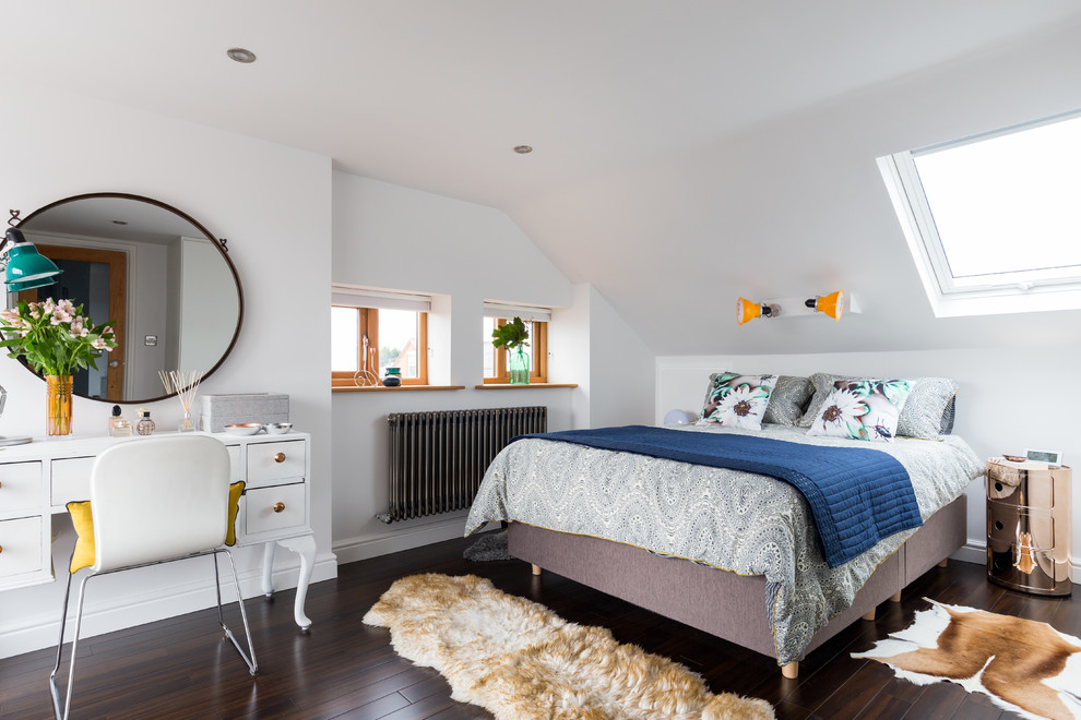 Klassisches Schlafzimmer ohne Kamin mit weißer Wandfarbe und dunklem Holzboden in London