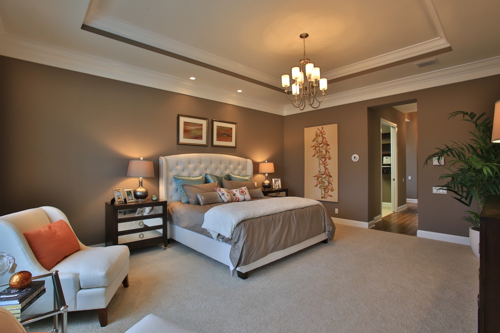 Diseño de dormitorio principal ecléctico grande sin chimenea con paredes beige y suelo de madera en tonos medios