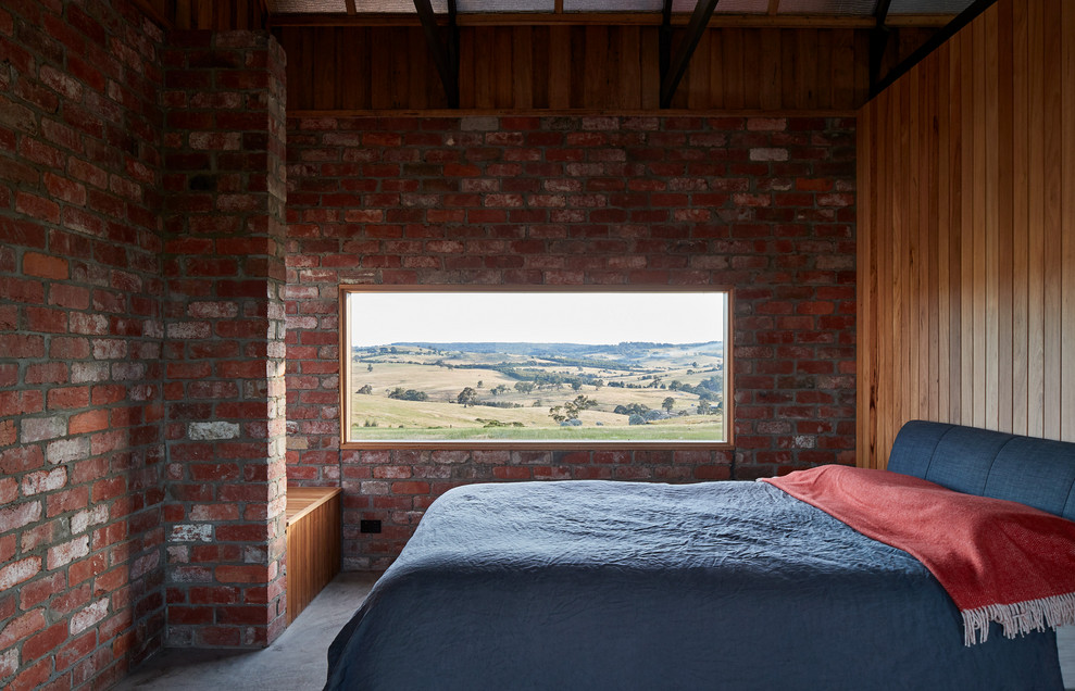 Diseño de dormitorio principal rural pequeño con paredes rojas, suelo de cemento y suelo gris