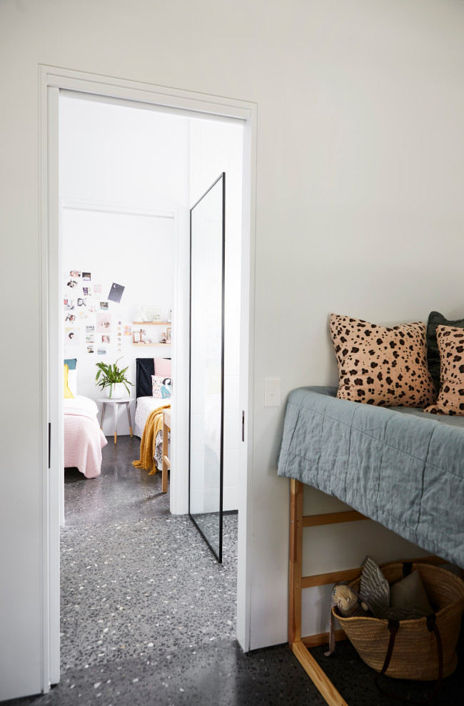 Foto de habitación de invitados minimalista grande con paredes blancas, suelo de cemento y suelo negro
