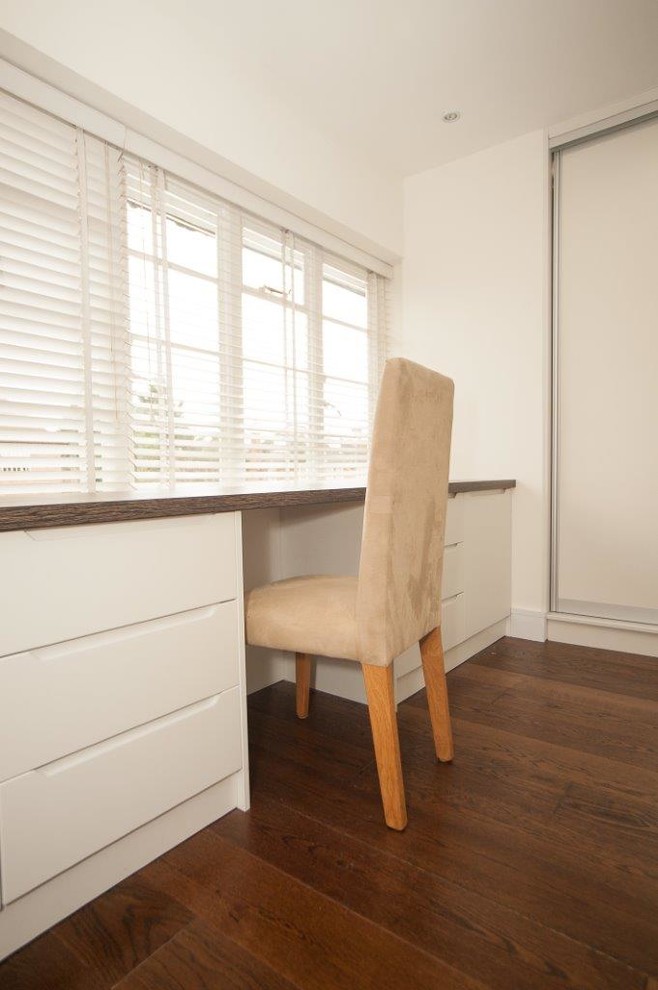 Aménagement d'une chambre parentale contemporaine de taille moyenne avec un mur blanc, un sol en bois brun, aucune cheminée et un sol marron.