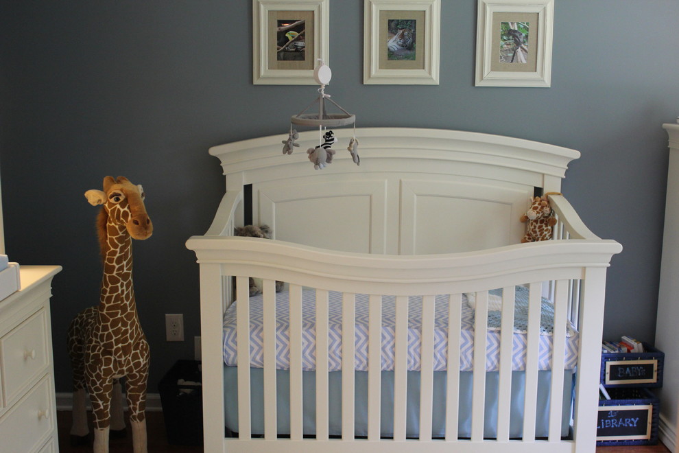 Exemple d'une petite chambre de bébé chic avec un mur bleu et un sol en bois brun.