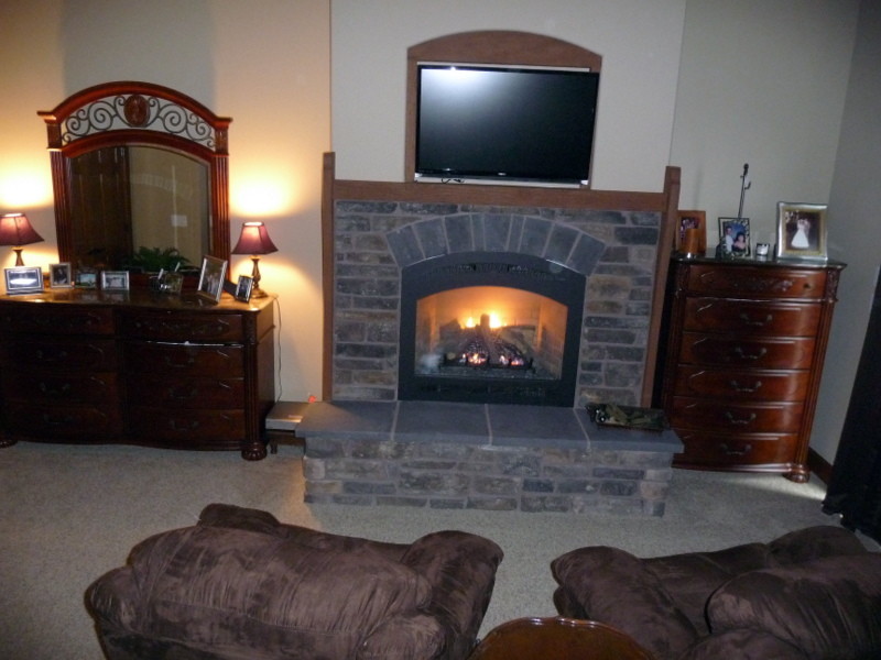 ポートランドにある広いトラディショナルスタイルのおしゃれな主寝室 (黒い壁、カーペット敷き、標準型暖炉、レンガの暖炉まわり)