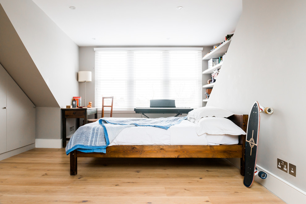 Diseño de habitación de invitados bohemia de tamaño medio con paredes grises y suelo de madera clara