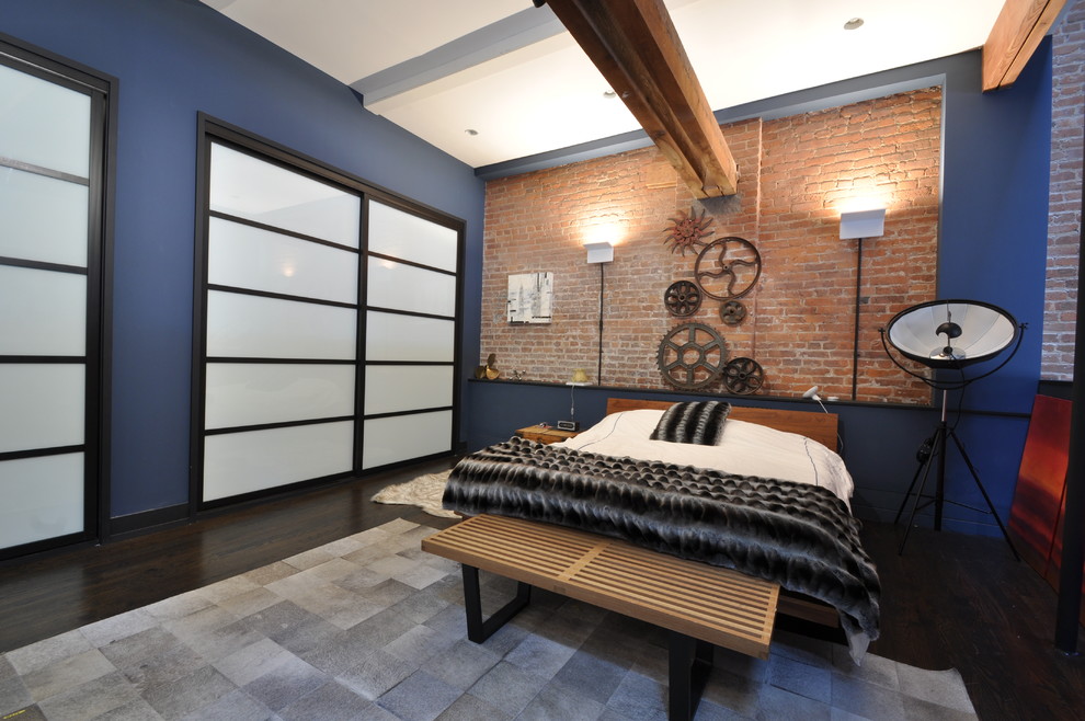 Mittelgroßes Industrial Schlafzimmer im Loft-Style, ohne Kamin mit dunklem Holzboden, blauer Wandfarbe und braunem Boden in New York