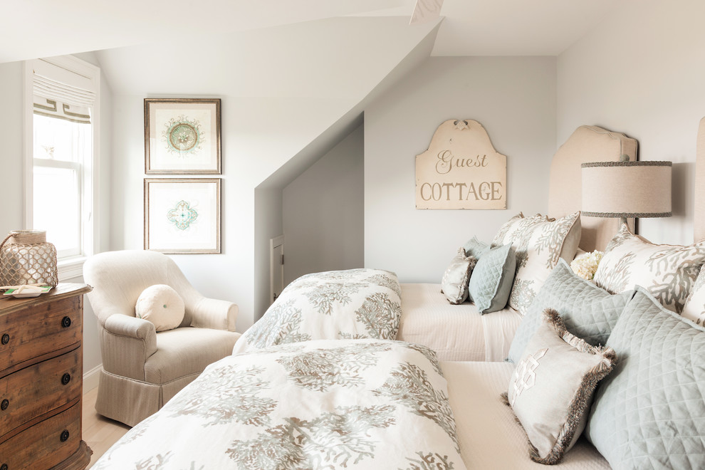 Diseño de habitación de invitados costera de tamaño medio sin chimenea con paredes beige y suelo de madera clara