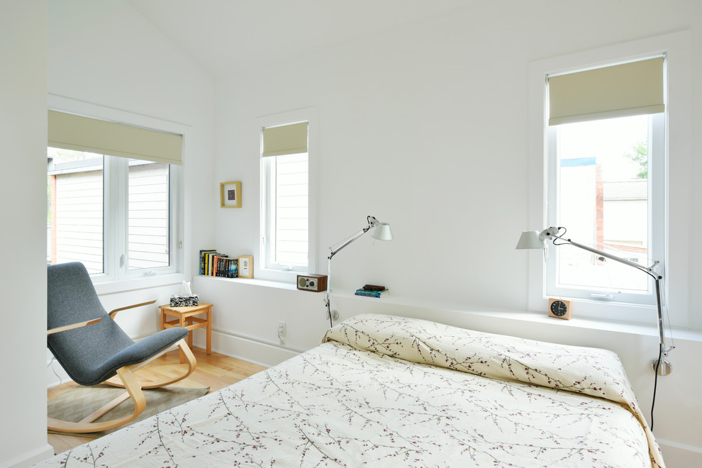 Modelo de dormitorio principal nórdico de tamaño medio con paredes blancas y suelo de madera clara
