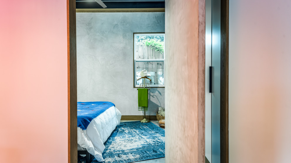 Mittelgroßes Eklektisches Hauptschlafzimmer mit grauer Wandfarbe, Betonboden und grauem Boden in Houston