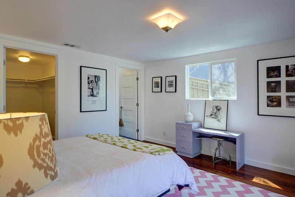 Inspiration pour une petite chambre d'amis design avec un mur blanc et un sol en bois brun.