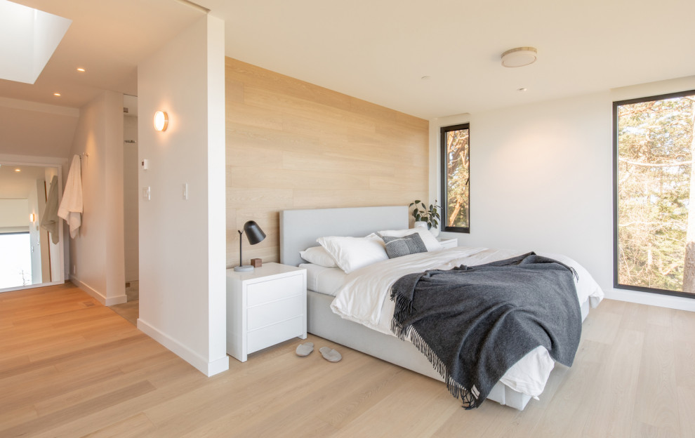 Idée de décoration pour une chambre parentale design en bois de taille moyenne avec un mur blanc, parquet clair et un sol beige.