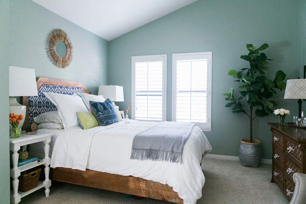 Foto de habitación de invitados bohemia de tamaño medio sin chimenea con paredes azules y moqueta