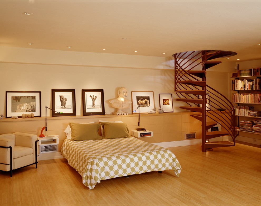 Ispirazione per una camera da letto design con pareti beige, pavimento in legno massello medio e nessun camino
