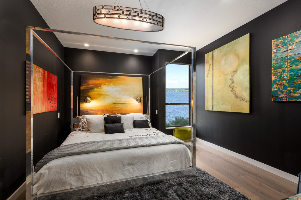Diseño de dormitorio principal moderno de tamaño medio sin chimenea con paredes negras, suelo de madera en tonos medios y suelo marrón