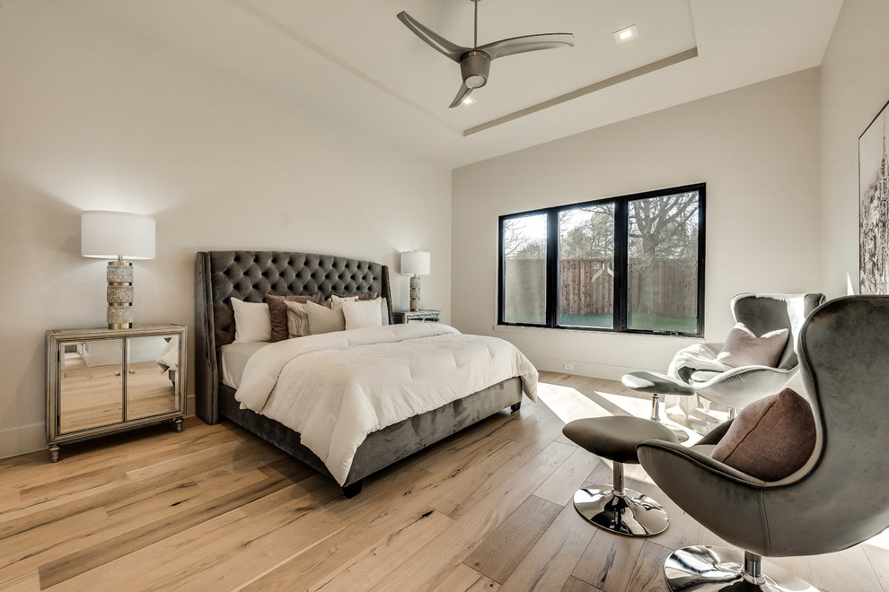 Ejemplo de dormitorio principal minimalista de tamaño medio con paredes beige, suelo de madera clara y suelo beige