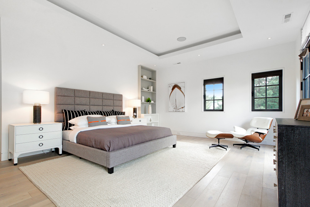 Ejemplo de dormitorio principal actual de tamaño medio con paredes blancas, suelo de madera clara y suelo beige