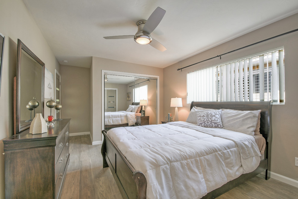 Imagen de dormitorio tipo loft contemporáneo de tamaño medio sin chimenea con paredes grises, suelo de madera clara y suelo gris