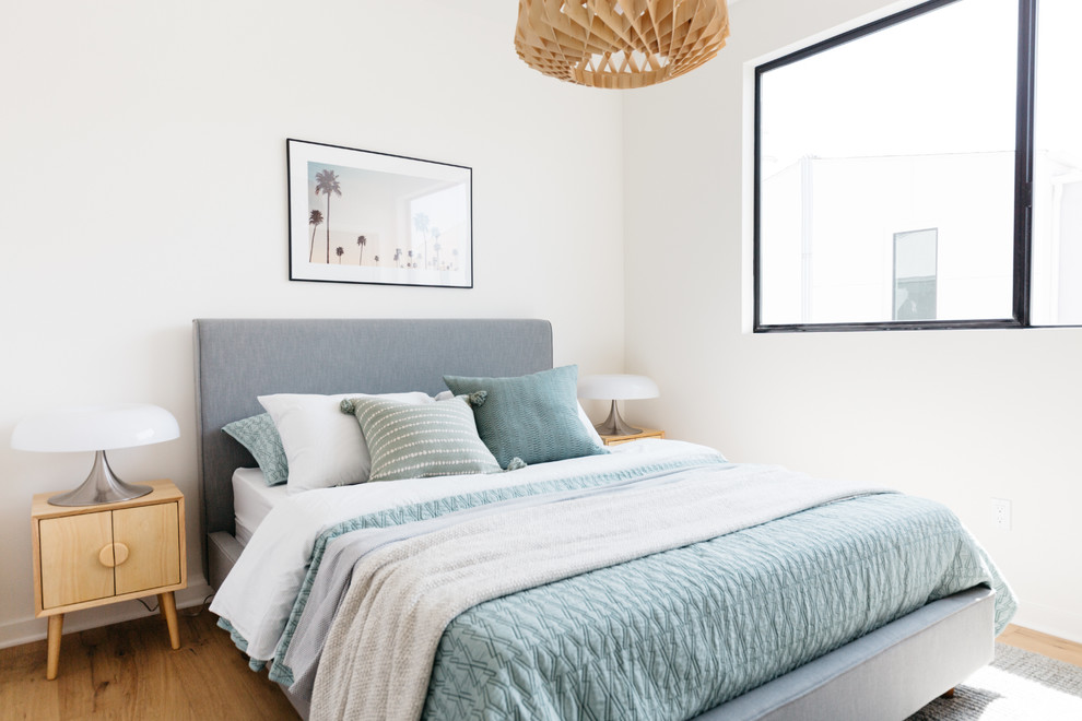 Imagen de dormitorio actual con paredes blancas, suelo de madera en tonos medios y suelo marrón