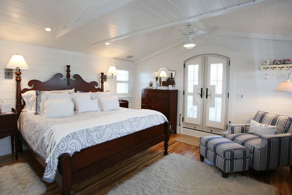 Immagine di una camera matrimoniale chic di medie dimensioni con pareti bianche e pavimento in legno massello medio