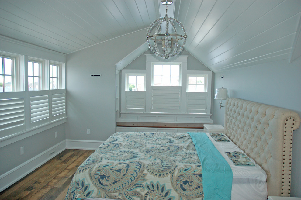 Imagen de dormitorio principal costero con paredes blancas, suelo de madera oscura y suelo beige