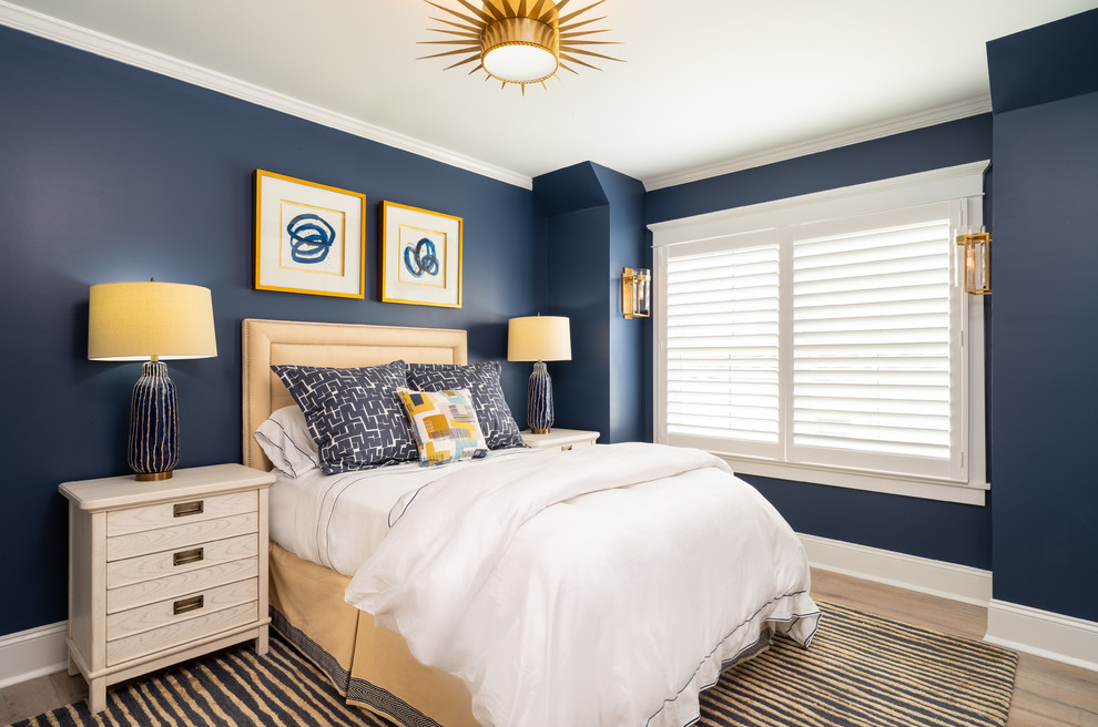 Imagen de habitación de invitados costera de tamaño medio con paredes azules, suelo de madera en tonos medios y suelo azul
