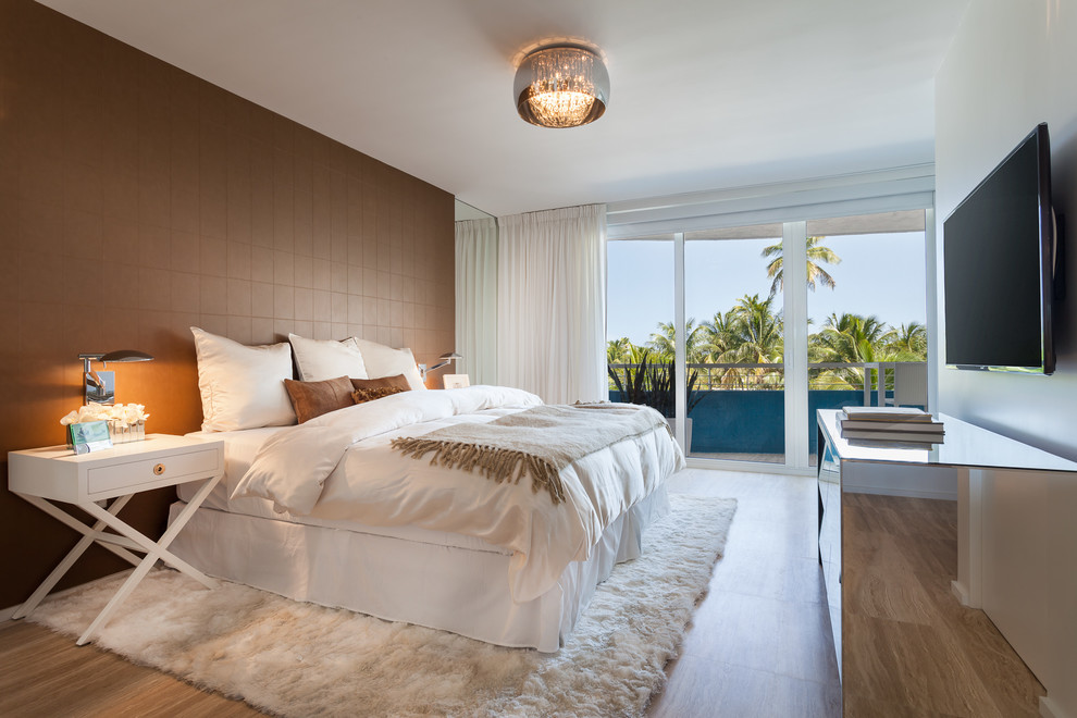 Mittelgroßes Modernes Hauptschlafzimmer ohne Kamin mit brauner Wandfarbe und hellem Holzboden in Miami