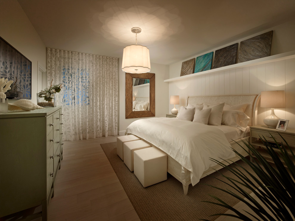 Design ideas for a coastal bedroom in Miami with white walls and light hardwood flooring.