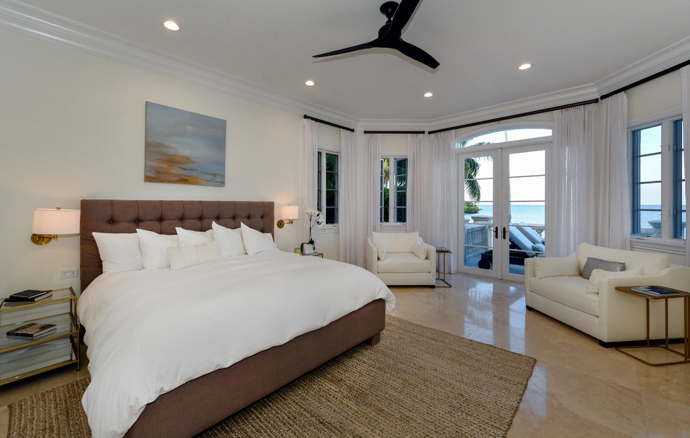 Стильный дизайн: большая хозяйская спальня в морском стиле с бежевыми стенами, полом из известняка и бежевым полом без камина - последний тренд