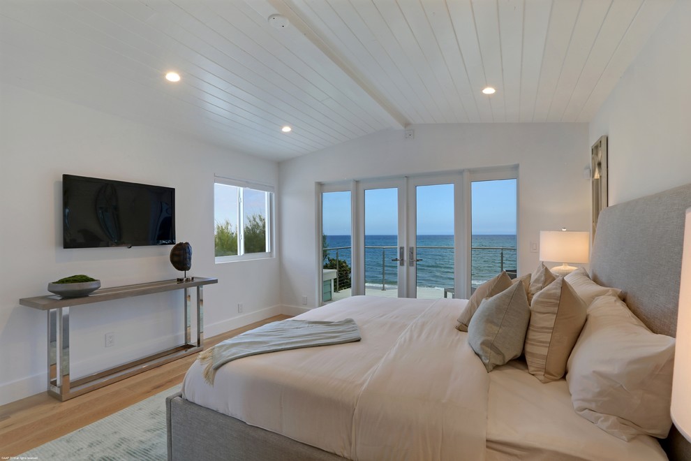 Modelo de habitación de invitados costera con paredes blancas, suelo de madera en tonos medios y suelo marrón