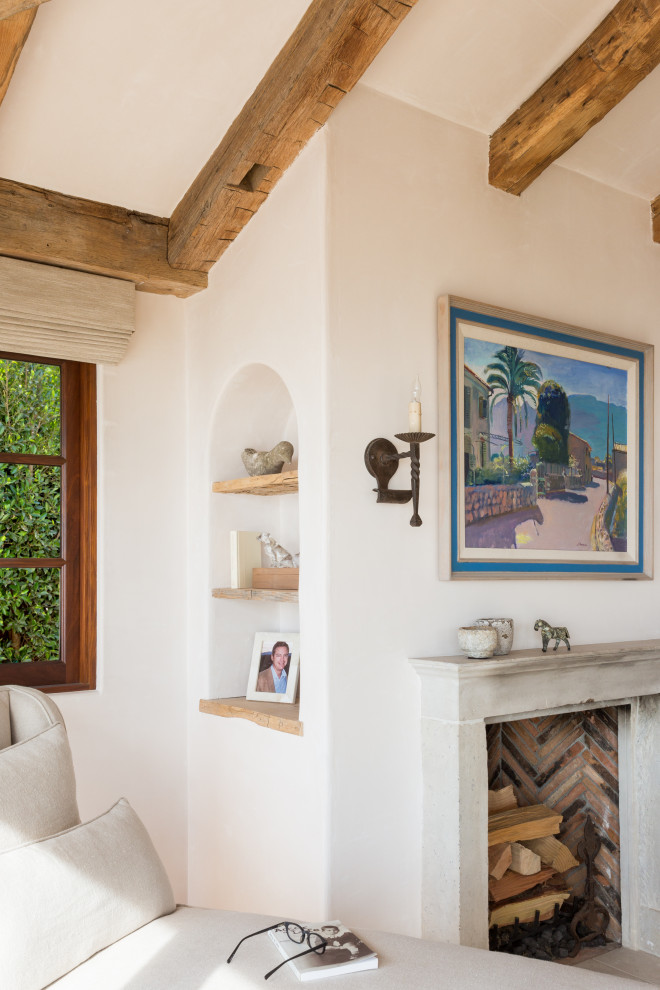 Aménagement d'une chambre parentale méditerranéenne de taille moyenne avec un mur beige, parquet clair, une cheminée standard, un manteau de cheminée en pierre, un sol beige et poutres apparentes.