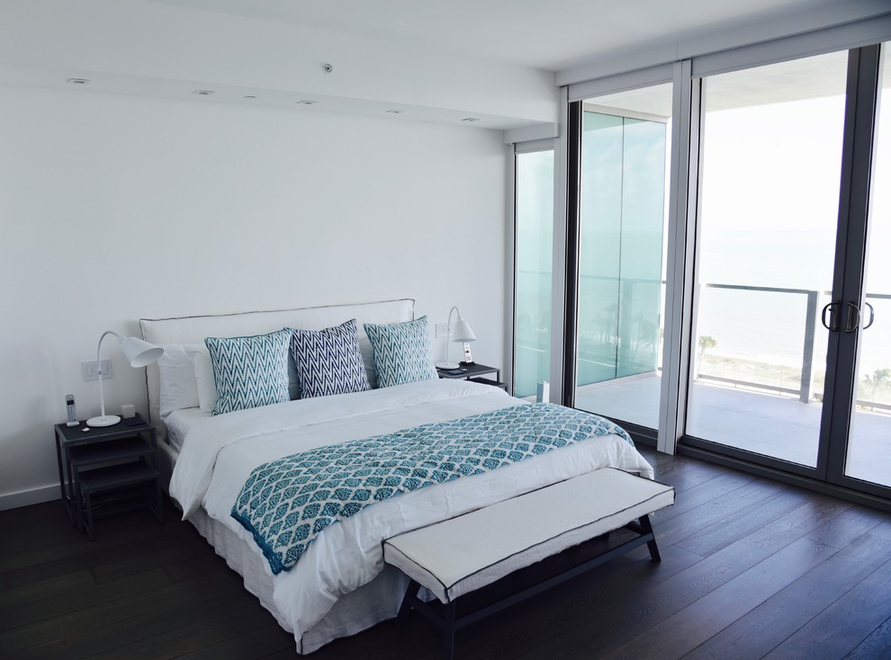 Imagen de dormitorio principal costero con paredes blancas y suelo de madera oscura