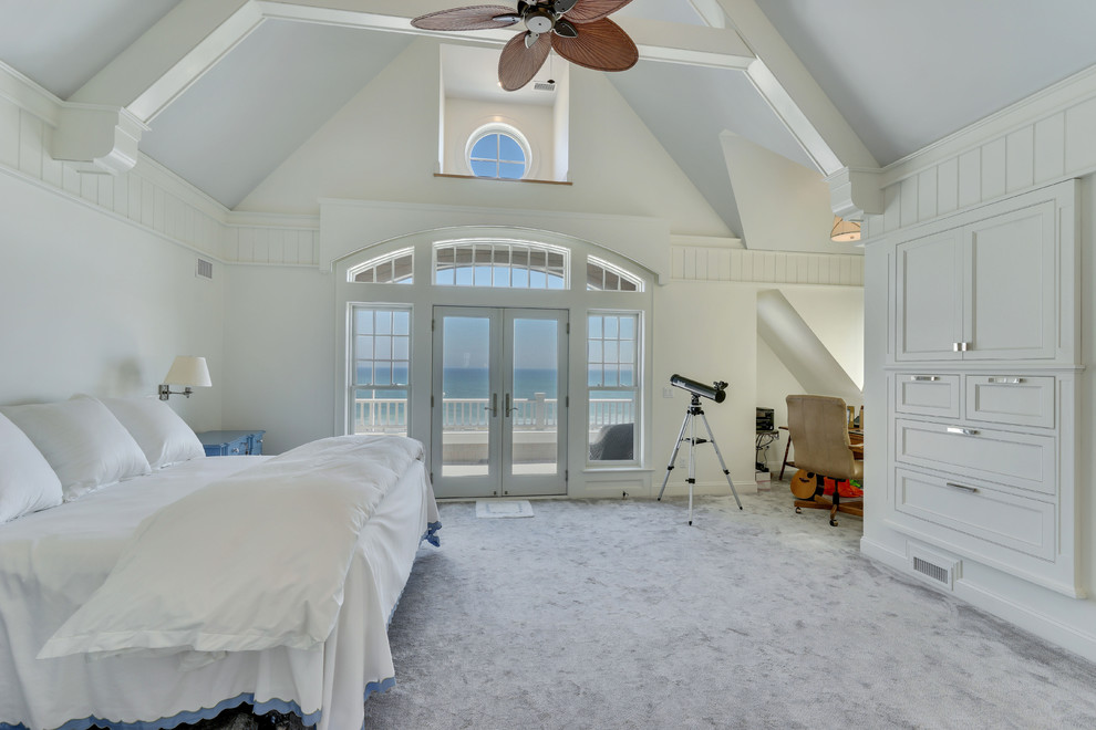 ニューヨークにある広いビーチスタイルのおしゃれな客用寝室 (白い壁、カーペット敷き、マルチカラーの床)