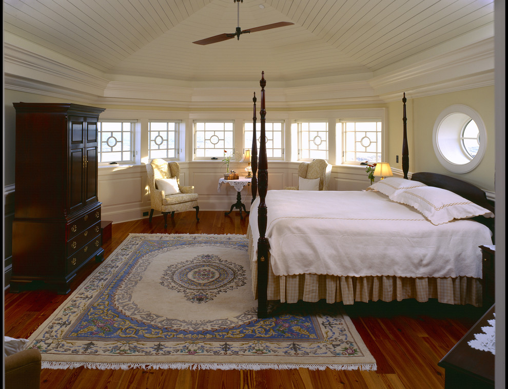 Пример оригинального дизайна: большая хозяйская спальня в викторианском стиле с желтыми стенами и паркетным полом среднего тона