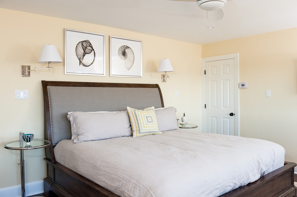 Photo of a large modern bedroom in Wilmington with yellow walls and dark hardwood flooring.