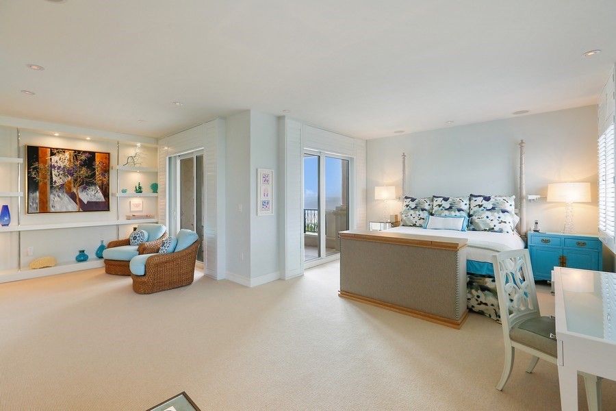 Geräumiges Hauptschlafzimmer ohne Kamin mit blauer Wandfarbe, Teppichboden und beigem Boden in Miami