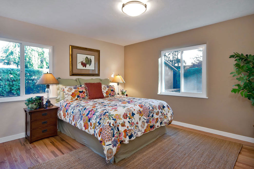 Diseño de dormitorio tradicional con paredes beige y suelo de madera en tonos medios