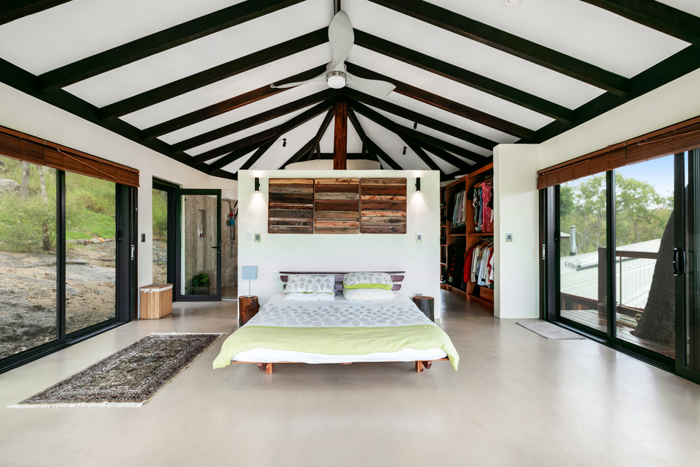 Großes Rustikales Schlafzimmer mit weißer Wandfarbe und Betonboden in Cairns